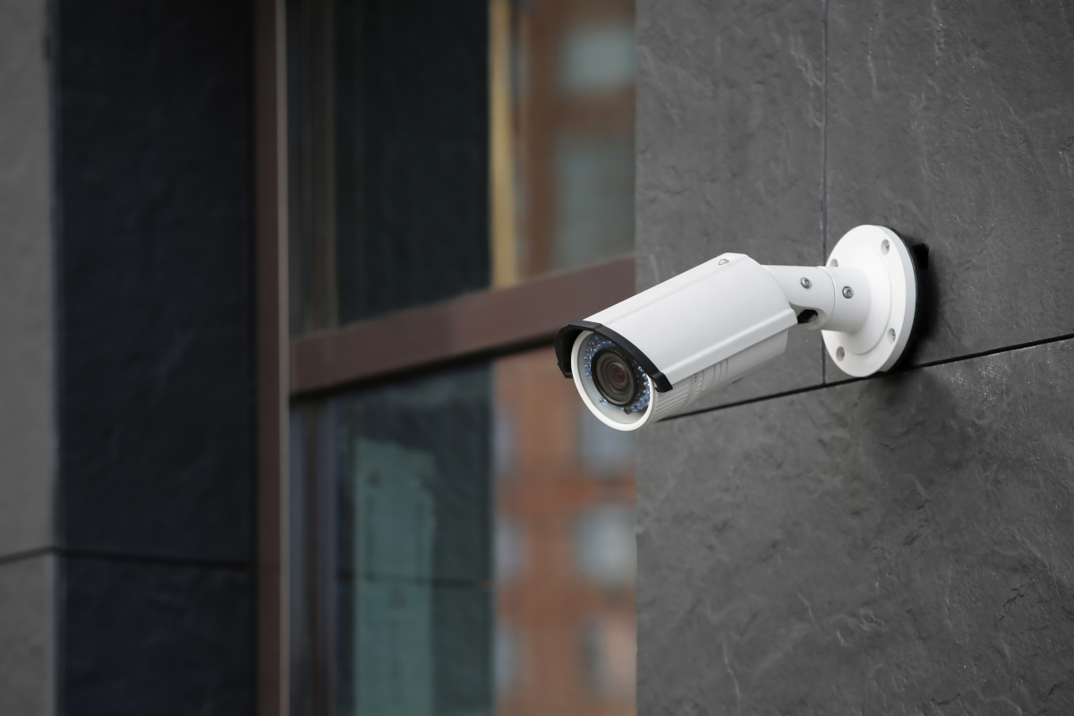 A modern surveillance camera mounted on the outside of a business