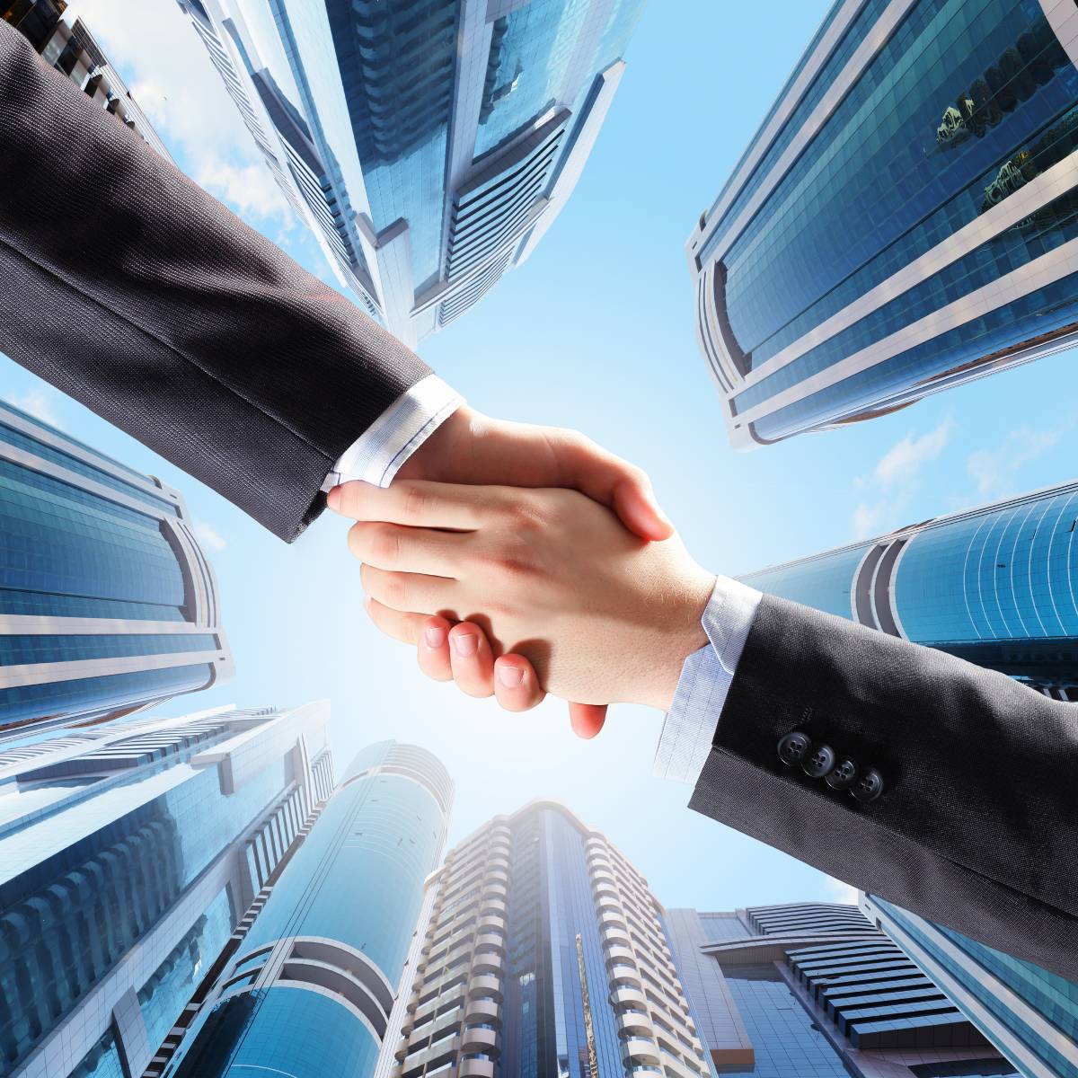 Two businessmen shaking hands with a city skyline in the background