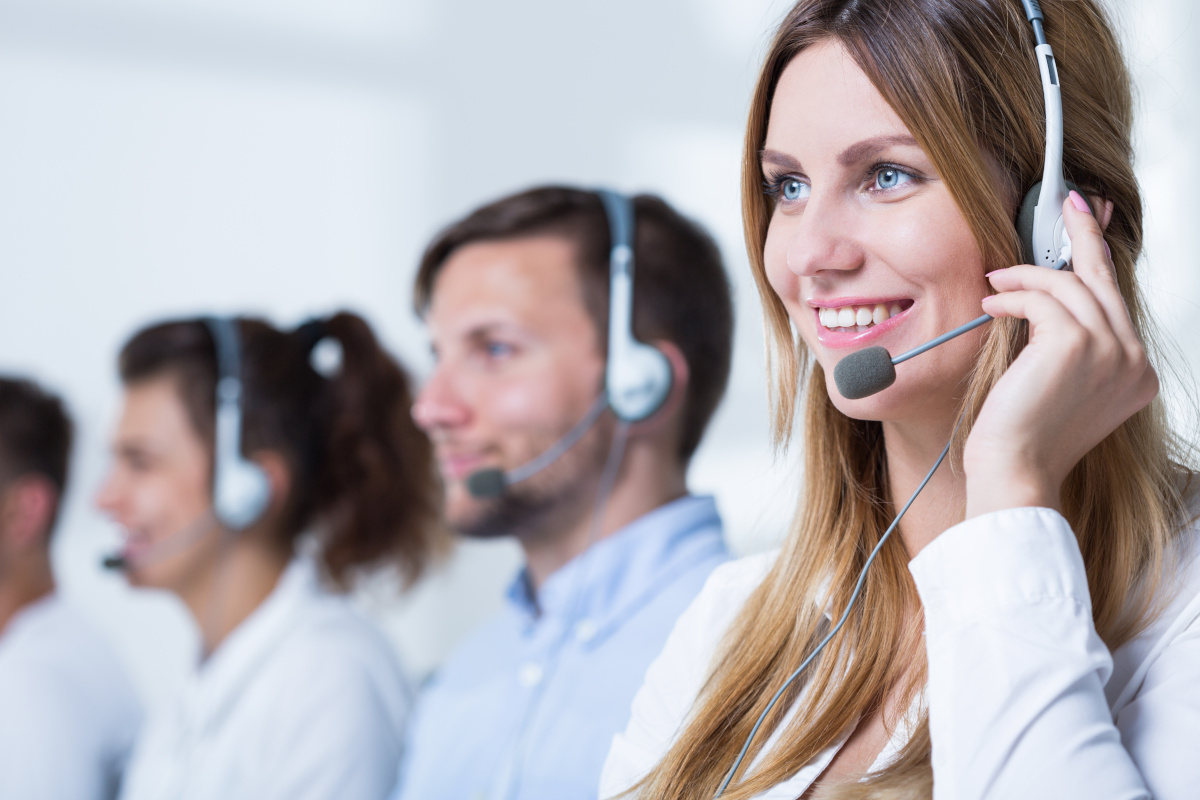 A smiling help desk employee wearing a headset
