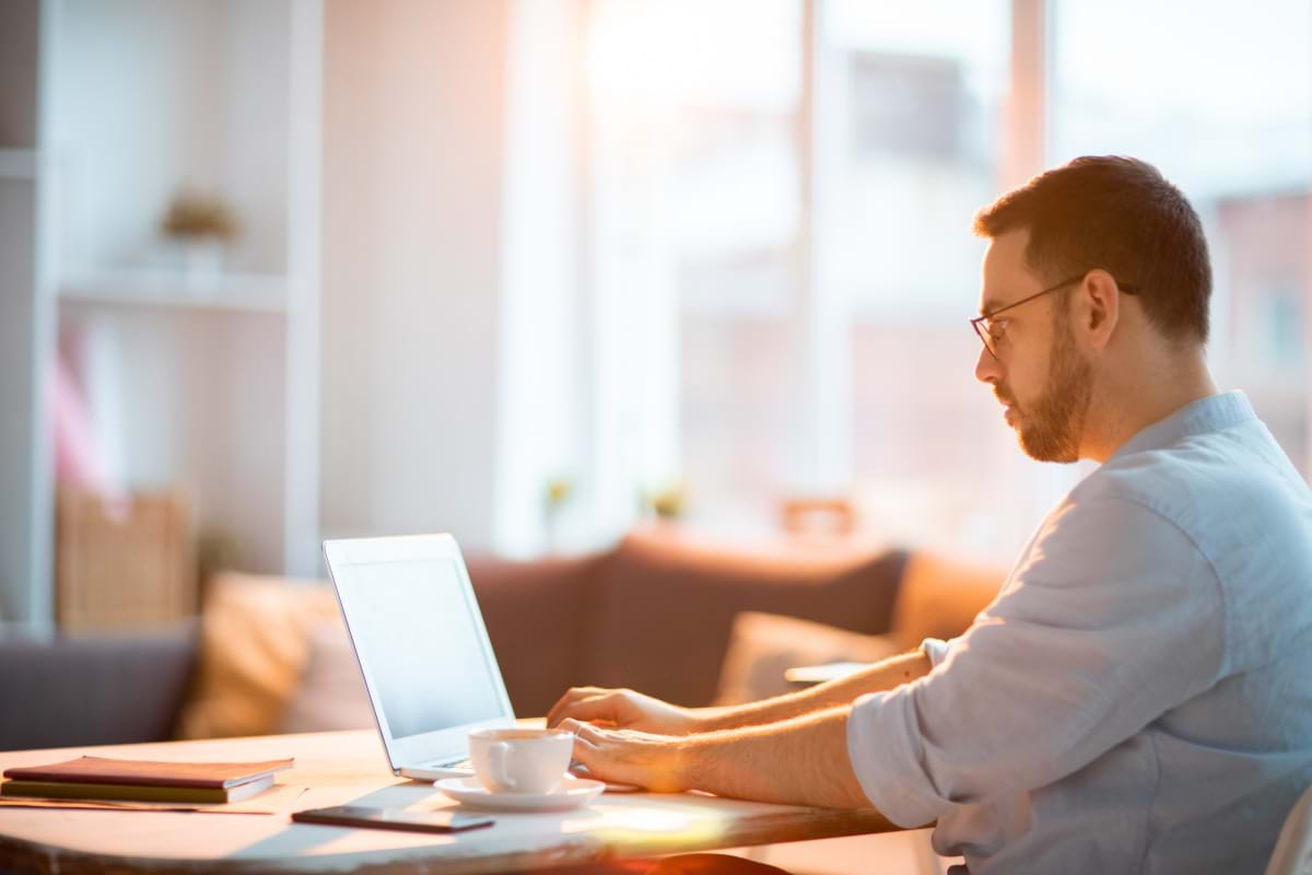 A man working at home on a laptop in his living room