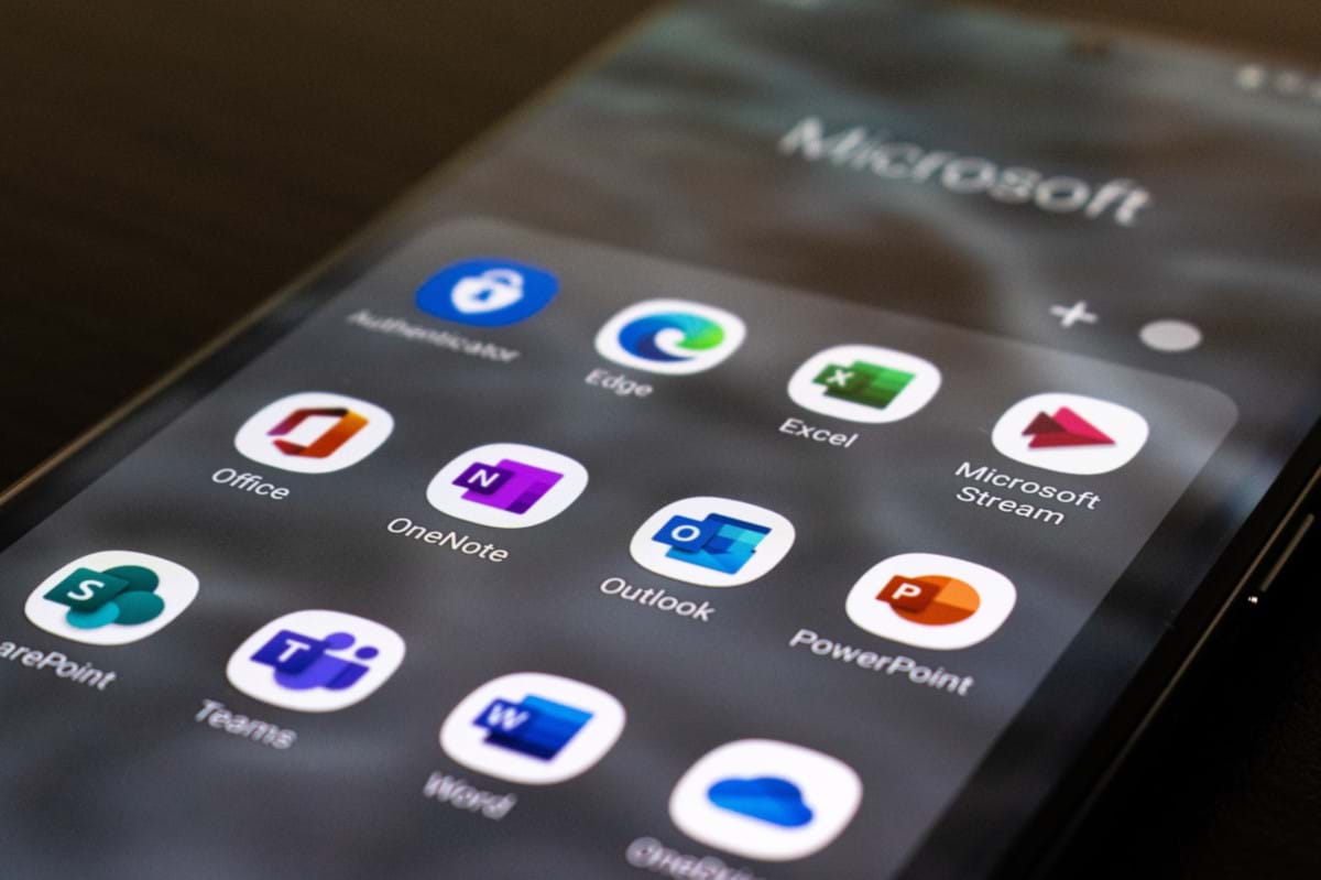 Closeup of a smartphone screen showing the app icons for all the Microsoft 365 applications.