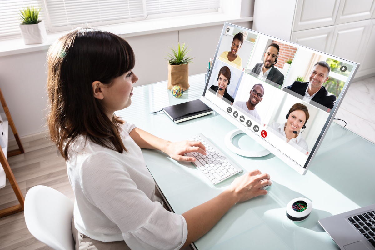 A woman using a computer to video chat with colleagues