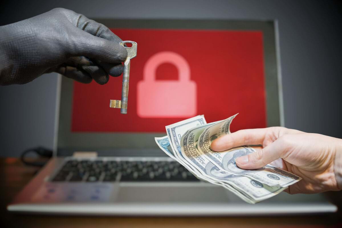 Man's hand trading hundreds of dollars for the key to unlock their data