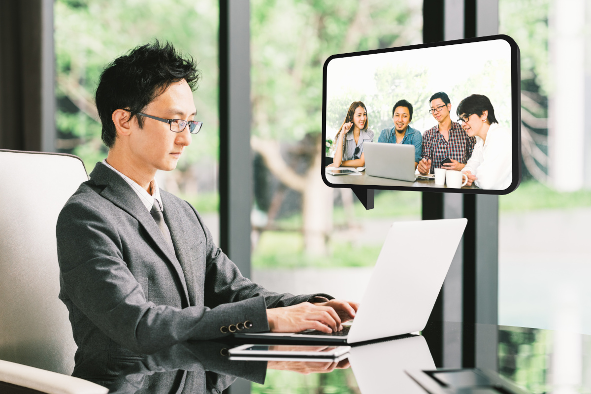 A man working from home and video conferencing with colleagues